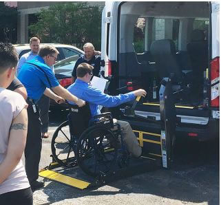 trainer showing how to load a passenger in a wheelchair onto a lift