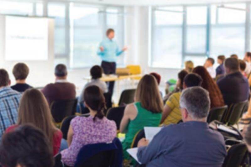 Image of people listing to speaker in a classroom