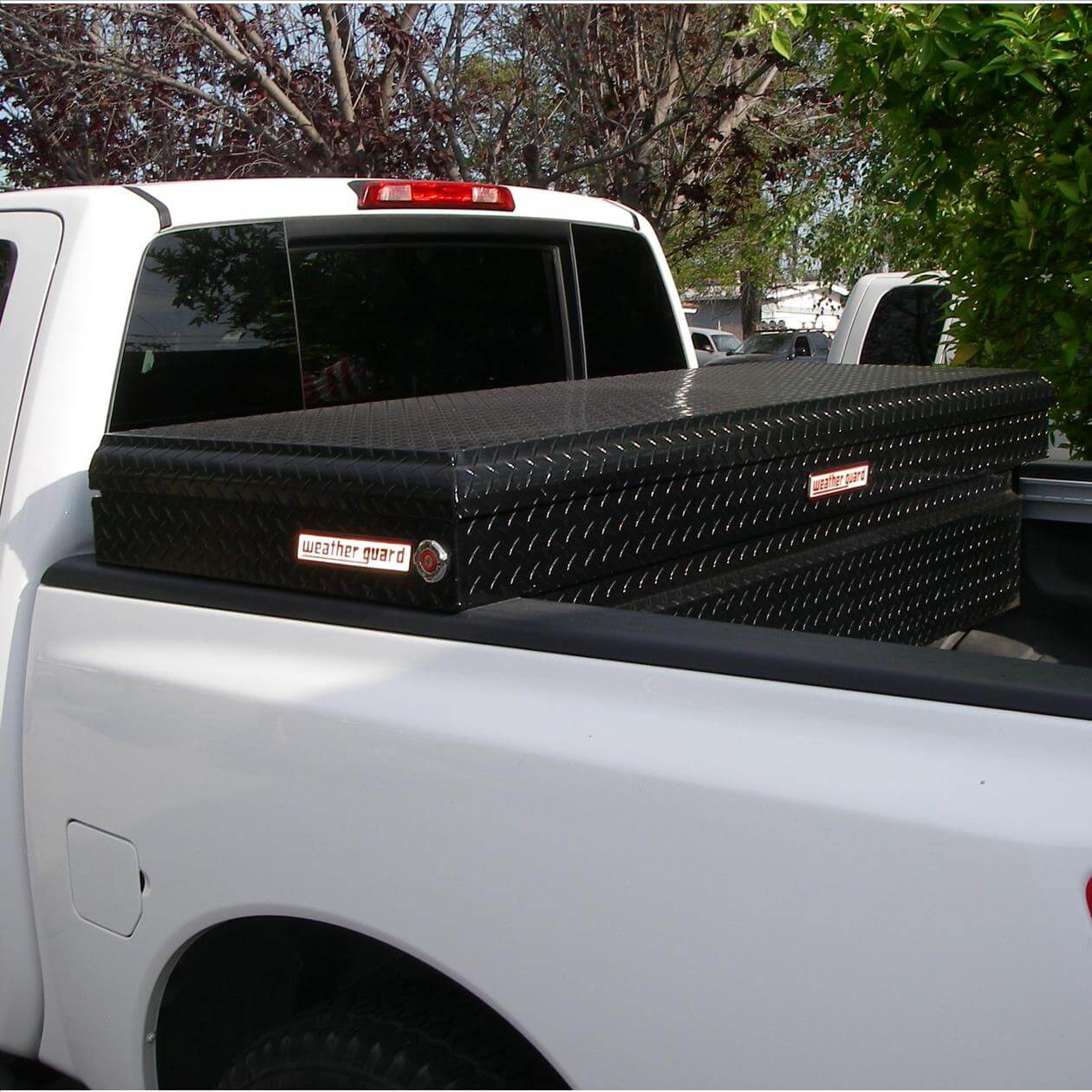 WG117_live A white pickup truck with a black diamond-plate toolbox mounted in the bed.