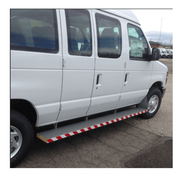 A white passenger van with a red and white striped side step parked on an asphalt surface.