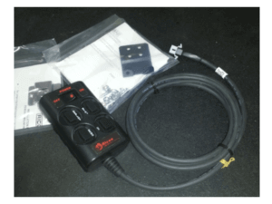 Electronic control switch with multiple buttons, a coiled cable, mounting bracket, screws, and instruction sheet placed on a dark surface.