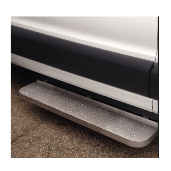 A close-up of a metal running board attached to the side of a white vehicle, positioned above an asphalt surface.