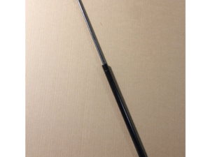 A single gas strut with black and metallic components is shown against a plain cardboard background.