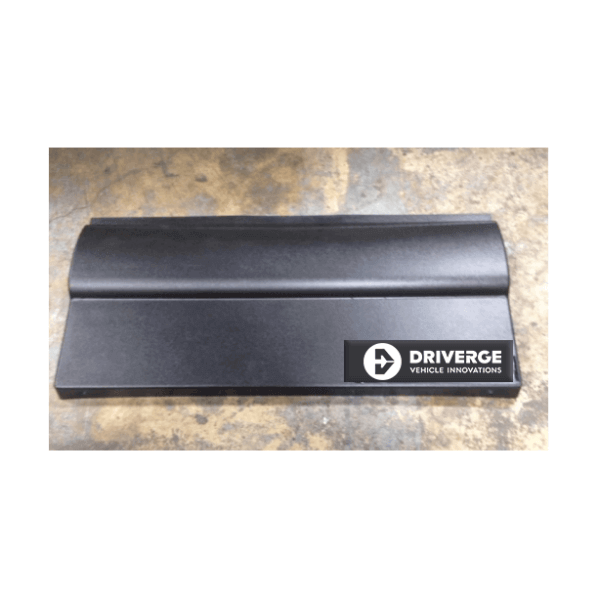 A black automotive part is placed on a concrete floor, with a Driverge Vehicle Innovations logo in the lower right corner of the image.