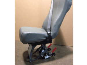 A single gray vehicle seat with a seatbelt, mounted on a black metal frame, positioned against a plain brown background.