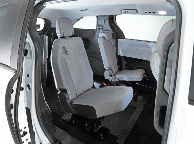 Interior view of a Toyota Sienna Hybrid showing two rows of individual gray fabric seats with ample legroom, a modern, minimalist design, and convenient rear-entry access. Interior view of a Toyota Sienna Hybrid showing two rows of individual gray fabric seats with ample legroom, a modern, minimalist design, and convenient rear-entry access.