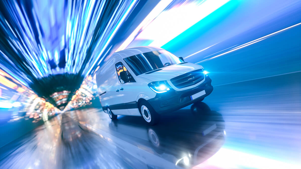 A white commercial van builder’s vehicle drives at high speed through a tunnel with blue and purple motion blur effects, suggesting rapid movement or fast delivery.