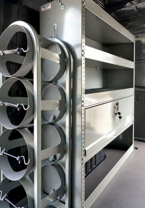 The interior of a vocational van features metal shelves and cylindrical racks, perfect for organizing HVAC tools or materials efficiently. The interior of a vocational van features metal shelves and cylindrical racks, perfect for organizing HVAC tools or materials efficiently.